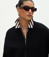 Campera de punto de corte regular y estilo oversized, confeccionada en una mezcla de viscosa, poliéster y poliamida. Presenta cierre frontal completo, mangas largas con puños acanalados y acabado acanalado en el ruedo.