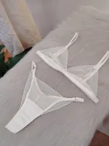 Conjunto de lencería compuesto por un corpiño triangular y una bombacha tipo tanga, confeccionados en encaje con diseño de ondas y terminaciones delicadas.