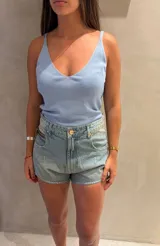 Blusa tejida sin mangas de color celeste, con escote en V y tirantes finos.