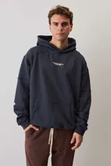 Hoodie canguro de friza en color azul marino, con capucha ajustable, bolsillo frontal tipo parche y estampa tipográfica pequeña en el pecho.