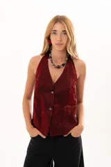 Chaleco de corte sastrero en color bordó, con acabado satinado y textura arrugada. Presenta escote en V profundo, cierre frontal con botones y diseño sin mangas.