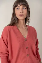 Cárdigan negro de punto con escote en V y cierre frontal con botones marrones.