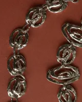 Pulsera de eslabones circulares con diseño orgánico y textura irregular, elaborada artesanalmente en metal con acabado dorado.