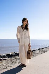 Blusa de lino color beige con transparencias, diseño de rayas horizontales y detalles ajurados en la parte frontal y mangas.