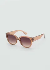 Gafas de sol de diseño redondo con montura de pasta en color marrón translúcido y lentes degradadas con protección UV.