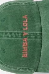 Gorro de visera estilo dad hat, color marrón oscuro o negro lavado, con bordado frontal multicolor que parece decir "BMBAYLO".