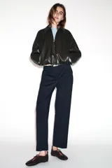 Pantalón tobillero de corte recto en color beige, con detalle de nervio delantero marcado. Incluye cinturón fino, bolsillos delanteros y cierre frontal con cremallera, botón interior y gancho.