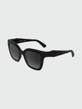 Lentes de sol Longchamp con armazón de acetato negro de diseño cuadrado y patillas anchas con detalle metálico. Lentes con degradado oscuro.