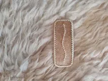 Broche para pelo artesanal de cuero con bordados en tiento fino.