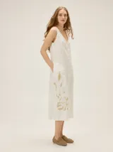 Vestido midi blanco sin mangas de lino, con escote en V y un estampado botánico en tono beige en la parte inferior de la falda.