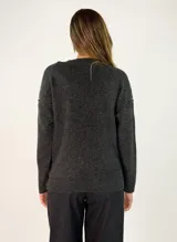 Sweater de punto gris con cuello en V, manga larga y detalles de costuras decorativas en color negro a lo largo del centro y en las mangas.