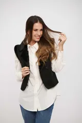 Chaleco negro de gamuza sintética con interior de piel sintética, diseño sin mangas y cierre frontal con botones.