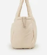 Cartera tipo shopper de gran tamaño, confeccionada en poliéster con acabado acolchado y textura lisa. Presenta un diseño de trapecio invertido con correas integradas para llevar al hombro y cierre superior con cremallera.