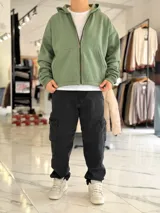 Campera tipo canguro con cierre frontal completa y capucha, de corte boxy fit en color blanco marfil. Presenta bolsillos frontales tipo parche y puños y dobladillo en rib elástico.
