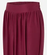 Pantalón de corte aladino con volumen en las piernas, confeccionado en tejido piquet. Presenta cintura elástica y detalle de lazos para anudar en los tobillos.