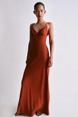 Vestido largo de corte recto y color teja, con escote en V y tirantes finos. Presenta detalles de acabados en tejido satinado combinado a tono en el escote y cierre lateral con cremallera oculta.