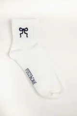Medias blancas con bordado de moño azul marino en el tobillo y logo de la marca en el lateral.