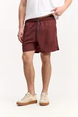 Short de baño azul, de corte clásico y largo corto, con cintura elástica y cordón ajustable bicolor. Cuenta con bolsillos laterales y uno trasero.