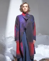 Tapado largo de lana merino afieltrada color rojo y violeta con diseño degradado. Tiene bolsillos laterales y puede usarse suelto o cruzado.