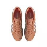 Championes adidas modelo Gazelle, confeccionados en gamuza color naranja con las icónicas tres tiras laterales en blanco. Presentan suela de goma color caramelo y detalle de talón en blanco.