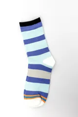 Pack de tres pares de medias estilo crew con diseños geométricos y combinaciones de colores celestes, azules, naranjas y blancos.