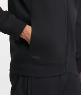 Buzo deportivo negro con capucha, cierre frontal con cremallera, bolsillos laterales y puños ajustados. Confeccionado en tejido de algodón y poliéster.