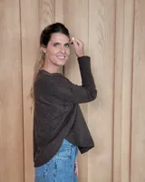 Sweater de punto color beige, con cuello en V, manga larga con puños acanalados y diseño holgado.