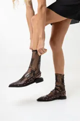 Chatas de cuero con punta fina, tira en el empeine con hebilla doble y tachas plateadas. Incluye una tira trasera con tachas. Disponibles en negro y marrón.