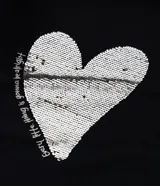 Remera de algodón color negro, con cuello redondo y mangas cortas. Presenta una estampa central en forma de corazón realizada con lentejuelas reversibles en tonos dorados y plateados.