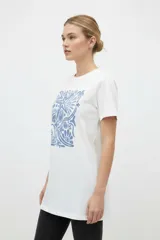 Remera de manga corta color azul con estampa frontal oscura de una ballena decorada con motivos florales.