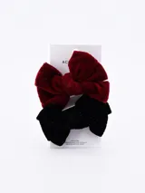 Set de dos pinzas para el pelo con moños de terciopelo, una color borgoña y otra negra.