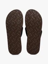 Ojotas negras con suela de EVA y tiras de tejido trenzado en color negro. Presentan un logo bordado en la tira del dedo.