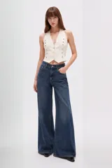 Pantalón jean de tiro medio, corte ancho y silueta holgada, confeccionado en denim azul con efecto deslavado.