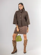 Chaqueta tipo capa de lana bouclé en color marrón, con cuello mao y cierre frontal de botones grandes. Presenta mangas tres cuartos con puños ajustados de tejido acanalado.