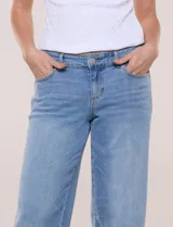 Jean wide leg de tiro medio y corte amplio, color azul claro. Presenta cintura con presillas, acceso frontal mediante cierre y botón metálico, y diseño de cinco bolsillos clásicos.