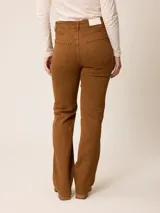 Jean de corte recto y tiro alto, confeccionado en denim azul oscuro con costuras en contraste. Presenta diseño clásico de cinco bolsillos, cierre frontal con botón y bragueta.