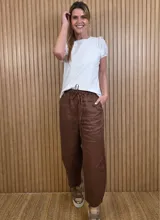 Pantalón de lino color marrón con corte barrel, tiro medio, cintura elástica con cordón de ajuste y bolsillos laterales.