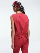 Chaleco estructurado de denim color terracota, con escote en V, cierre frontal con botones y bolsillos laterales tipo ojal.