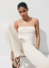 Pantalón blanco de tiro regular con diseño de pernera recta y estructura de tejido plano ligero.