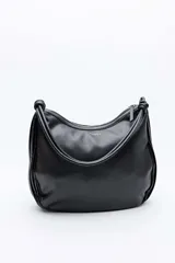 Bolso tipo hobo Daniel Cassin modelo Bolden, color negro, con diseño plisado y asa de hombro con nudos decorativos en los extremos.