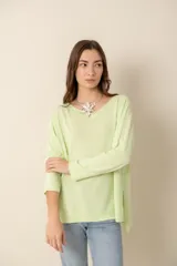 Sweater verde claro liso de manga larga con cuello bote y aberturas laterales.