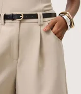 Bermuda sastrera de poliéster color beige, con corte recto, presillas en la cintura y bolsillos laterales.