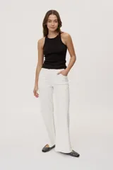 Pantalón de tiro medio y corte wide leg color beige, con diseño clásico de cinco bolsillos, presillas para cinto y cierre frontal con botón y cremallera.