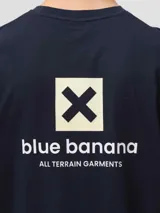 Camiseta de manga corta en color azul marino, con cuello redondo y corte clásico. Presenta un pequeño estampado en el pecho que incluye el logo de la marca y una cruz dentro de un cuadrado.