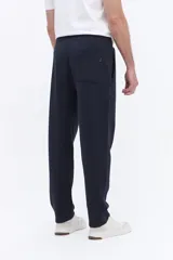 Pantalón de jogging con corte recto y ajuste relajado, confeccionado en tejido de algodón y poliéster. Cuenta con cintura elástica con cordón de ajuste y bolsillos laterales funcionales.