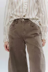 Jean de corte wide leg y tiro alto, confeccionado en denim de color azul oscuro. Presenta costuras decorativas visibles en los laterales y un diseño de pierna amplia.