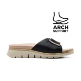 Sandalia de mujer Korium Confort Yaiza, con capellada de cuero sintético negro, hebilla dorada, plantilla acolchada y suela beige con detalle de línea dorada.