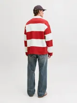 Buzo tipo polo de manga larga con diseño de franjas horizontales anchas en color rojo y blanco, cuello camisero blanco y cierre frontal parcial con solapa y botones ocultos.