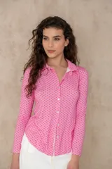 Camisa rosa con lunares rojos, de manga larga y cuello camisero.