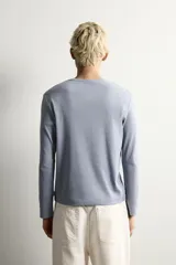 Camiseta de manga larga con cuello redondo, confeccionada en tejido con estructura de canalé y corte relajado.
